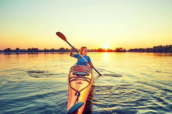 La gente kayak durante la puesta del sol en el fondo. Diviértete en tu f —  Fotos de Stock
