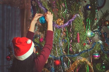 Noel hazırlığı, bir kız Noel ağacını süslüyor.