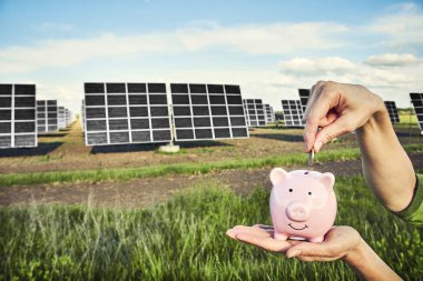 Arka planda fotovoltaik güneş enerjisi panelleri olan el ele tutuşma para banknotu, 