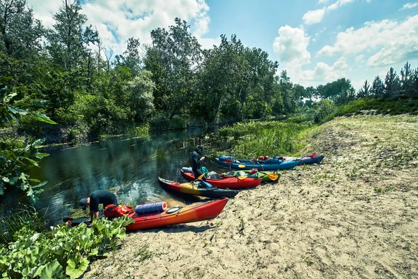 Bir grup genç kanoyla nehirde rafting yapıyor.