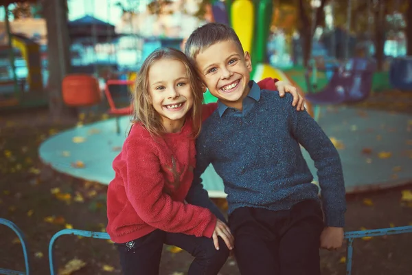 在一个阳光灿烂的秋日 两个穿着鲜艳毛衣的可爱的孩子在公园里散步 兄弟姐妹之间的友谊 快乐的家庭观念 — 图库照片