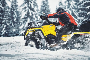 Ormanda kışın dört tekerlekli bisiklete binen sürücü.