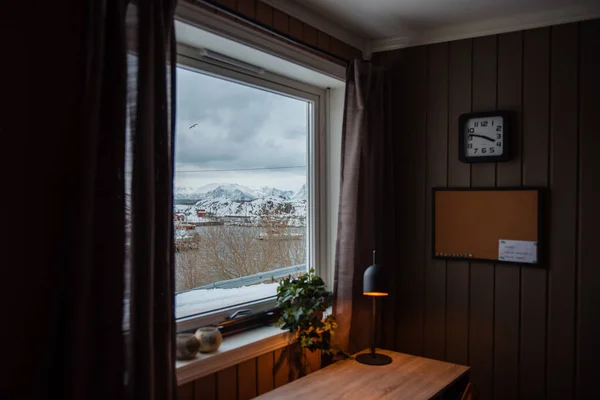 Penceresinden karlı dağlar görünen rahat bir oda..