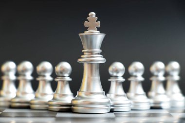 Gümüş Kral satranç parça standı önünde siyah arka plan (liderlik, yönetim kavramı üzerine piyon)