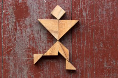 Neşeli adam şekil kırmızı eski ahşap arka plan üzerinde çalışan bulmaca Tangram