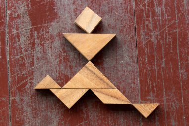Neşeli adam şekil kırmızı eski ahşap arka plan üzerinde çalışan bulmaca Tangram