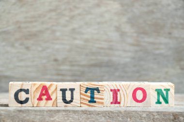 Mektup blok ahşap arka plan üzerinde kelime dikkat