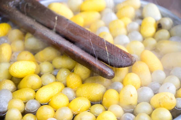 İpek makaralama için vintage yöntemi ve sıcak su arka planda sarı ve beyaz koza kapandı