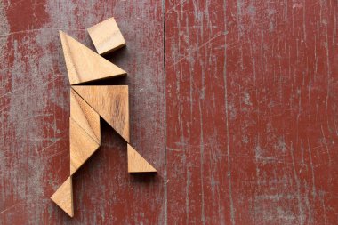 Tangram bulmacanın ile eğlenceli dans adam kırmızı eski ahşap arka plan üzerinde şekil