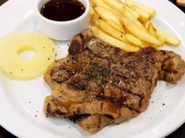 Domuz biftek dilimlenmiş ananas ve benli kişiler beyaz bulaşık arka plan üzerine ızgara