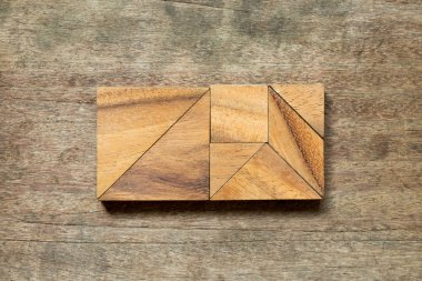 Ahşap arka plan üzerinde dikdörtgen şeklinde bulmaca Tangram