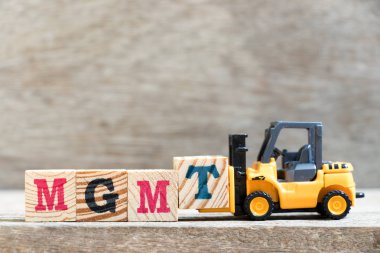 Oyuncak forklift kelime mgmt (kısaltma yönetimi) ahşap zemin üzerine mektup blok t hold
