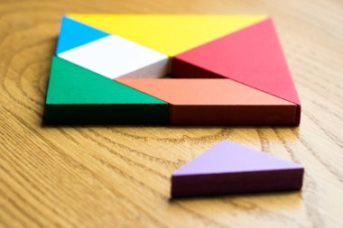 Tangram bulmacanın komple ahşap arka plan üzerinde bekleyin kare şeklinde