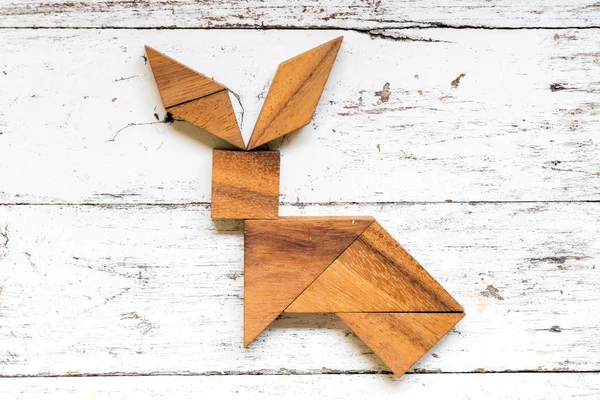 Tangram bulmacanın eski beyaz ahşap zemin üzerinde tavşan şeklinde
