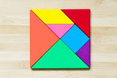 Ahşap arka plan üzerinde kare şeklinde renk tangram