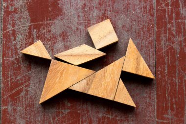 Kırmızı eski ahşap arka plan üzerinde at şekli kişini içinde bulmaca Tangram