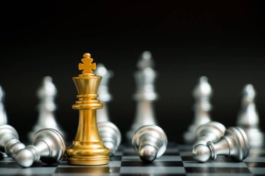 Satranç oyununda altın kral siyah zemin üzerinde başka bir gümüş takım ile karşı karşıya (Şirket stratejisi, iş zaferi veya karar kavramı)