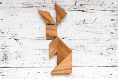 Tangram bulmacanın eski beyaz ahşap zemin üzerinde tavşan şeklinde