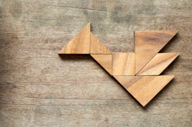 Tangram bulmacanın ahşap arka plan üzerinde kuş ya da ejderha şeklinde