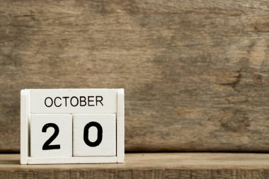 Mevcut tarih 20 ve ay Ekim ahşap arka plan üzerinde beyaz blok takvim