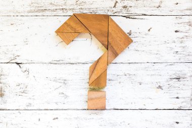 Söz konusu işareti şekli eski beyaz ahşap zemin üzerinde bulmaca Tangram