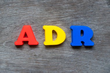 Word Adr (ters ilaç reaksiyonu kısaltma) ahşap arka plan üzerinde renkli plastik alfabesi