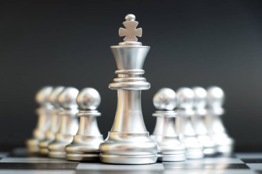 Gümüş Kral satranç parça standı önünde siyah arka plan (liderlik, yönetim kavramı üzerine piyon)