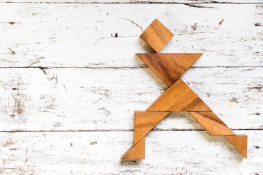 Eski Beyaz ahşap zemin üzerinde mutlu çalışan adam şeklinde bulmaca Tangram