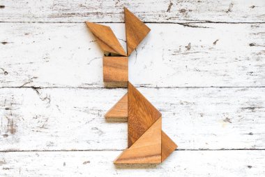 Tangram bulmacanın eski beyaz ahşap zemin üzerinde tavşan şeklinde