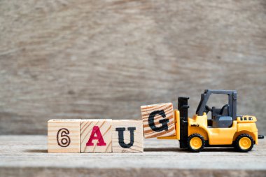 Oyuncak forklift tutun blok G tam word 6 Ağustos ahşap arka plan üzerinde (kavramı için takvim tarihi ay Ağustos)