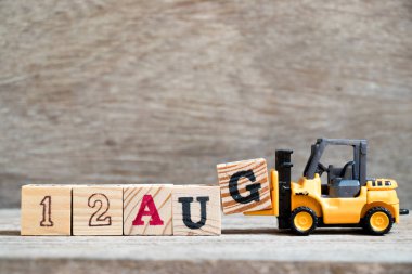 Oyuncak forklift tutun blok G tam word 12 Ağustos ahşap arka plan üzerinde (kavramı için takvim tarihi ay Ağustos)