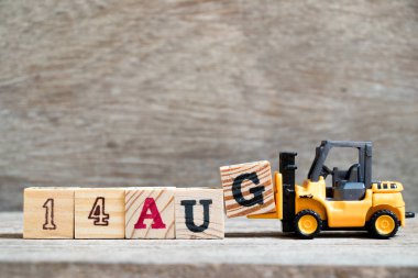 Ahşap arka plan üzerinde tam Word'e 14 Ağustos oyuncak forklift tutun blok G (kavramı için takvim tarihi ay Ağustos)