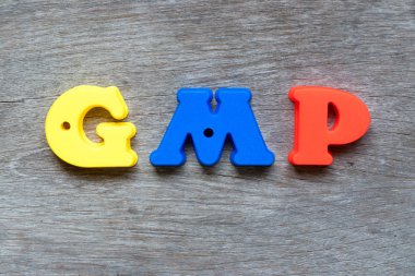Word Gmp (kısaltma iyi üretim uygulaması) ahşap arka plan üzerinde renkli plastik alfabesi