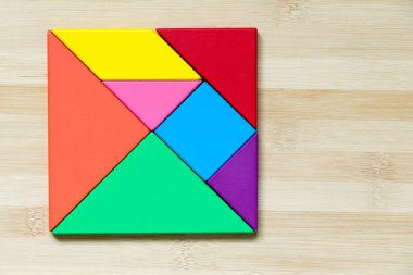 Ahşap arka plan üzerinde kare şeklinde renk tangram