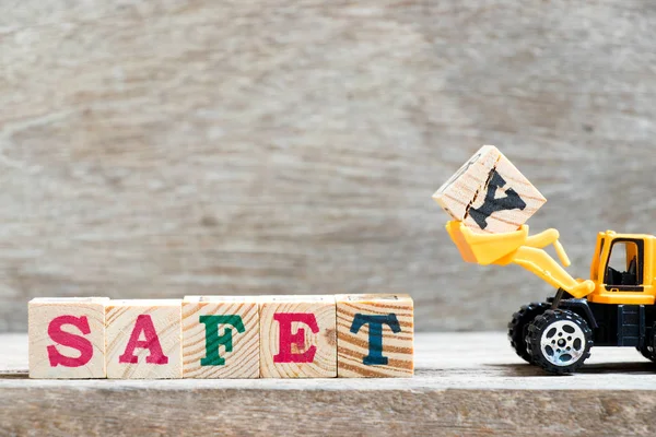 Spychacz Zabawka Przytrzymaj Literę Bloku Ukończenia Słowo Bezpieczeństwa Tle Drewna — Zdjęcie stockowe