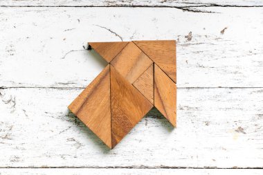 Eski Beyaz ahşap zemin üzerinde yön ok şeklinde bulmaca Tangram