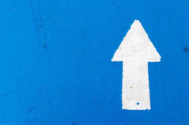 İleri yönde ok simgesi mavi beton yol arka plan üzerinde beyaz resim