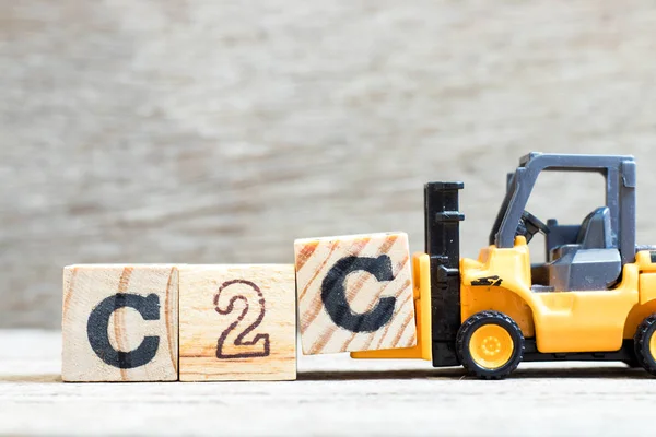 Word c2c tamamlamak için oyuncak forklift tutun harfi C blok (tüketiciye tüketici kısaltma) ahşap arka plan üzerinde