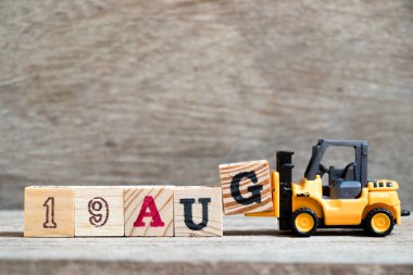 Oyuncak forklift tutun blok G ahşap arka plan üzerinde tam word 19 Ağustos (kavramı için takvim tarihi ay Ağustos)