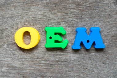 Word Oem (orijinal donatma imalatçı Abbbreviation) ahşap arka plan üzerinde renkli plastik alfabesi