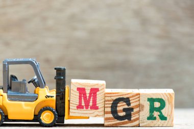 Oyuncak forklift kelime mgr (kısaltma Yöneticisi) ahşap zemin üzerine mektup blok m hold