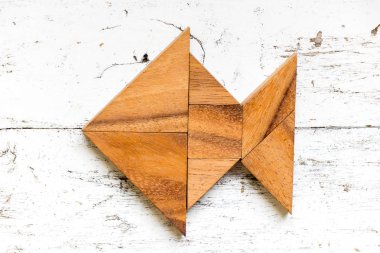 Eski Beyaz ahşap zemin üzerinde balık şeklinde bulmaca Tangram