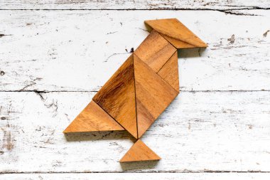 Tangram bulmacanın eski beyaz ahşap zemin üzerinde kuş şeklinde