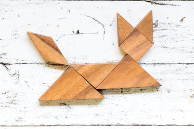 Tangram bulmacanın eski beyaz ahşap zemin üzerinde kedi şeklinde