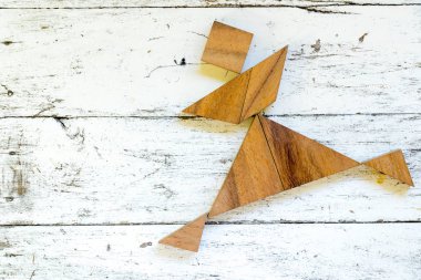 Eski Beyaz ahşap zemin üzerinde mutlu çalışan adam şeklinde bulmaca Tangram