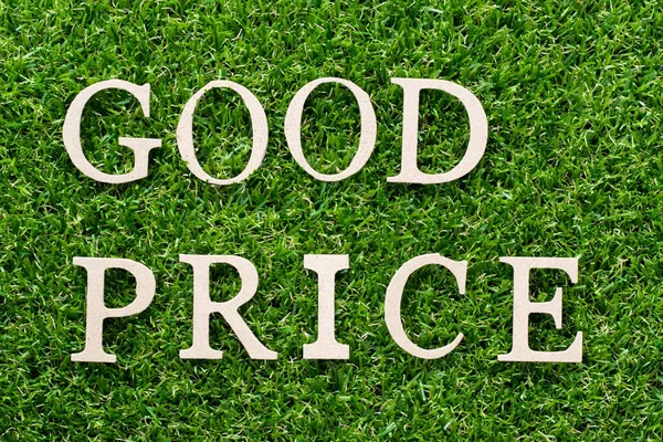 Wood alphabet in word good price on artificial green grass background