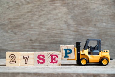 Oyuncak forklift blok P kelime 27 Eylül tarihinde ahşap arka plan (konsept için takvim tarihi Eylül ayında tamamlamak için basılı tutun)