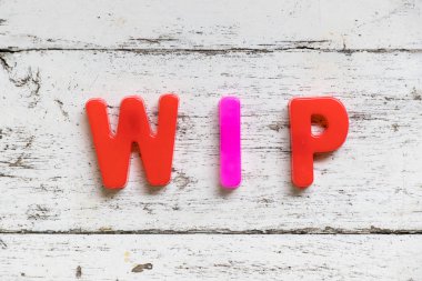 Word'de WIP (devam eden çalışma kısaltma) grunge eski beyaz tahta arka plan rengi alfabesi