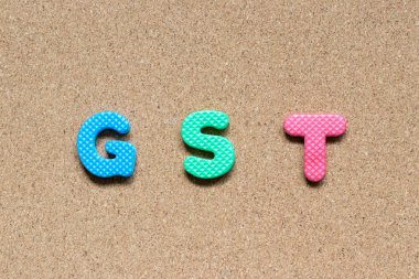 Kelime Gst (kısaltma mal ve hizmet vergisi) mantar pano arka plan üzerinde renkli köpük alfabesinde