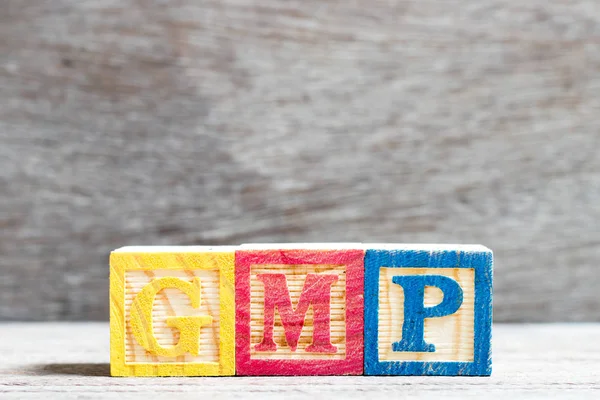 Color letter block in word GMP (Abbreviation of good manufacturing practice)  on wood background